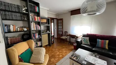 a living room with a couch and a book shelf at Nice apartment overlooking Ponferrada Castle in Ponferrada