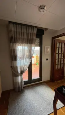 a room with a window with a curtain at Nice apartment overlooking Ponferrada Castle in Ponferrada
