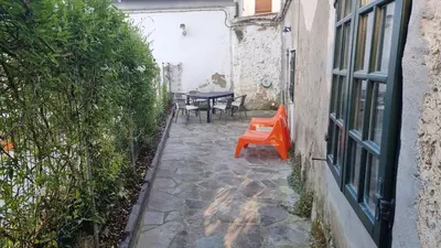 a patio with a table and chairs in a building at Precioso apartamento con patio centro de Castropol in Castropol