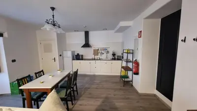 a kitchen and dining room with a table and chairs at Precioso apartamento con patio centro de Castropol in Castropol