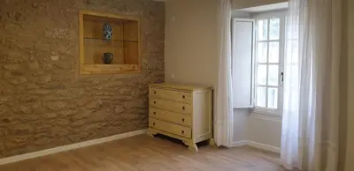 a bedroom with a wooden dresser and a window at Villa Victoria in Teo