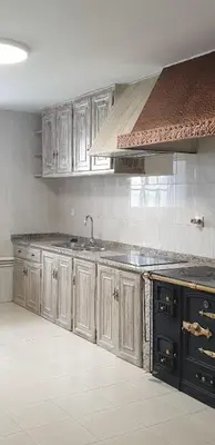 a kitchen with wooden cabinets and a sink at Villa Victoria in Teo
