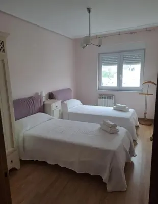 a white room with two beds and two windows at Arca de Noé in Valle de Oro