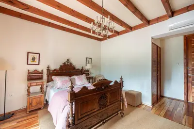 a bedroom with a wooden bed with pink pillows at Casa Doña Blanca, Ourense in San Clodio