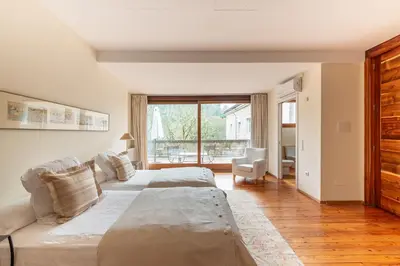 two beds in a room with a large window at Casa Doña Blanca, Ourense in San Clodio