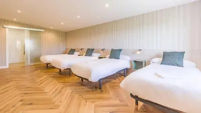a row of beds lined up in a room at Pensión 9 de Abril in O Pedrouzo