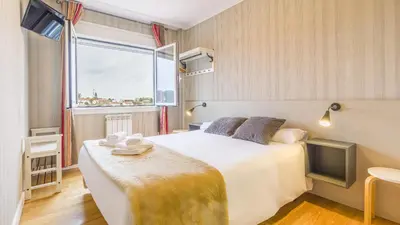 a hotel room with a bed and a window at Pensión 9 de Abril in O Pedrouzo