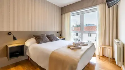 a hotel room with a bed and a window at Pensión 9 de Abril in O Pedrouzo