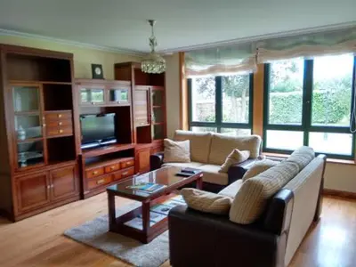 a living room with a couch and a tv at A Lúa do Camiño in Melide
