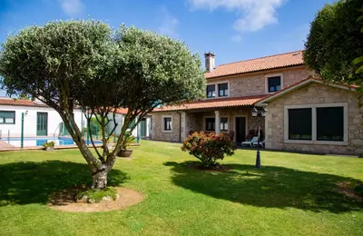 a house with a tree in the yard at A Lúa do Camiño in Melide
