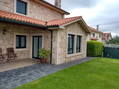a house with a green lawn in front of it at A Lúa do Camiño in Melide
