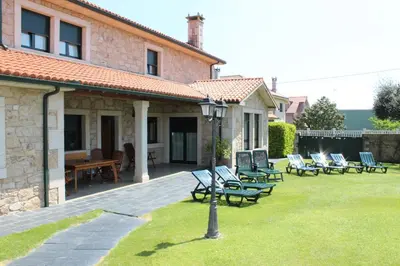 a group of chairs sitting on a lawn in front of a house at A Lúa do Camiño in Melide