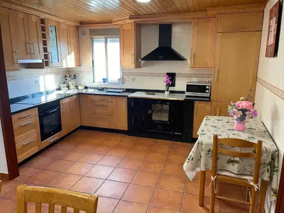 a kitchen with a table and a stove top oven at Casa da Greta in Parada del Monte