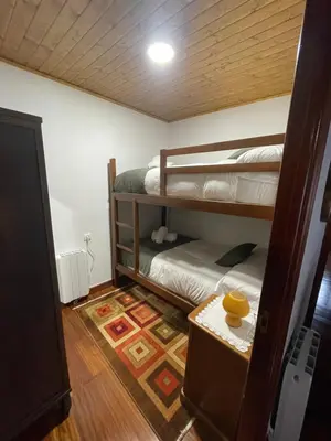 a room with two bunk beds and a table at Casa da Greta in Parada del Monte