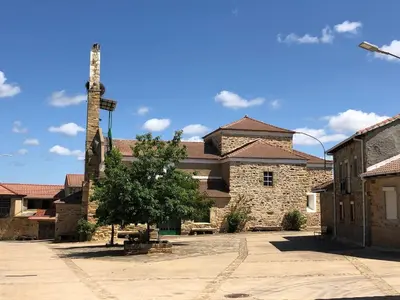 an old stone church with a tower in a courtyard at Mis antepasados in Murias de Pedredo