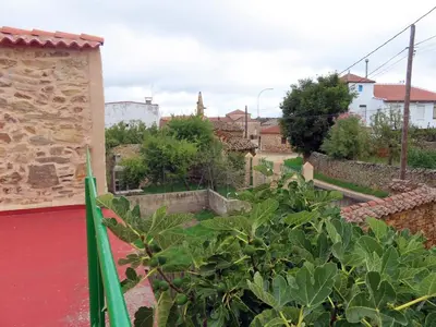 a view of a garden with a building and trees at Mis antepasados in Murias de Pedredo