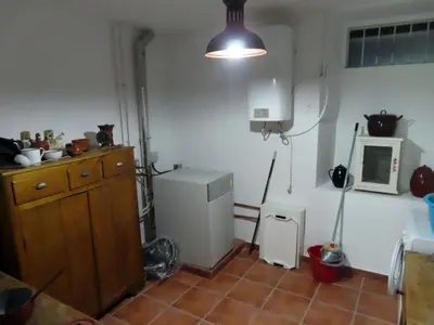 a room with a kitchen with a refrigerator and a light at Mis antepasados in Murias de Pedredo