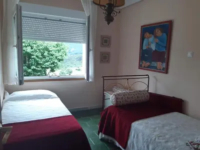 a bedroom with two beds and a window at Casa Vallejo en Crecente in Crecíente