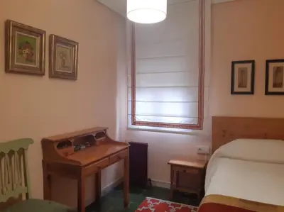 a bedroom with a desk and a bed and a window at Casa Vallejo en Crecente in Crecíente
