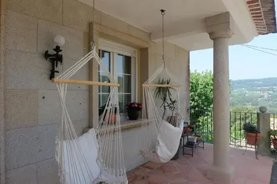 two white hammocks hanging on a porch at Casa Vallejo en Crecente in Crecíente