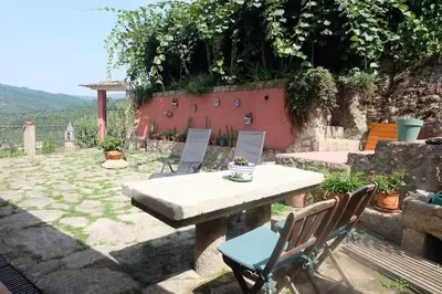a patio with a table and chairs in a yard at Casa Vallejo en Crecente in Crecíente
