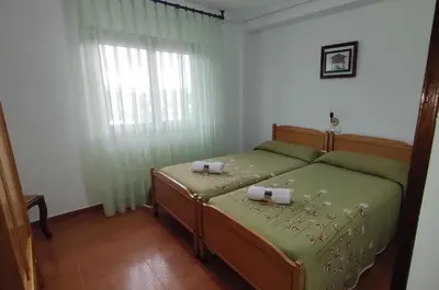 a bedroom with a bed with two candles on it at Pension Parrilla Casa Vicente in Tineo