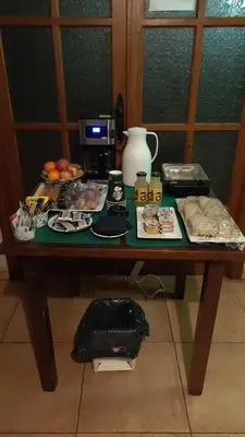 a table with a coffee maker and food on it at Pension Parrilla Casa Vicente in Tineo