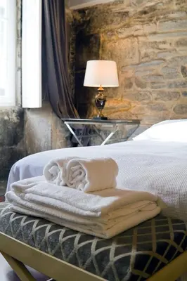 a bedroom with a bed with a table with a lamp at Inicia Casas Reales in Santiago de Compostela