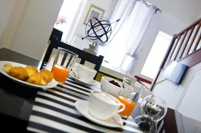 a table with a plate of food and orange juice at Inicia Casas Reales in Santiago de Compostela