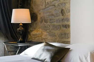 a bedroom with a bed and a lamp on a table at Inicia Casas Reales in Santiago de Compostela