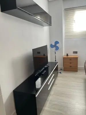 a black desk in a room with a fan at Universidad Piso Artur II in Ourense