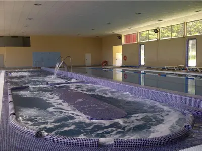 a large swimming pool with a large tub of water at Dupléx en Estación de Manzaneda in Prada