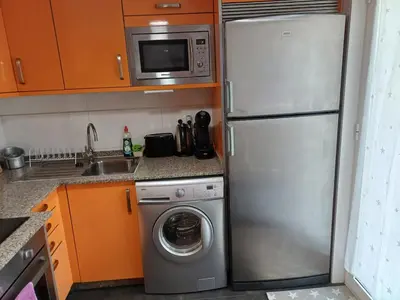 a kitchen with a refrigerator and a washing machine at Xove Home Mar de Lugo in Jove
