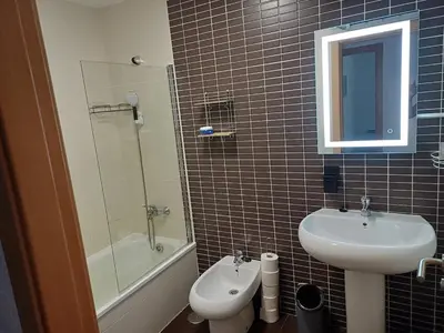 a bathroom with a sink and a toilet and a mirror at Xove Home Mar de Lugo in Jove