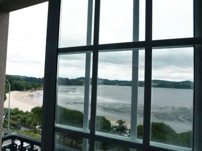 a view of a beach from a window at Apartamento O Cobo Miño in Miño