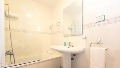 a white bathroom with a sink and a shower at Apartamento O Cobo Miño in Miño