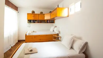 a small bedroom with two beds and a window at Apartamento O Cobo Miño in Miño