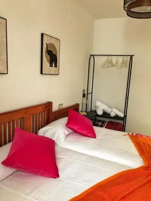 two beds with red pillows in a bedroom at Dulce Mañana in Portomarin