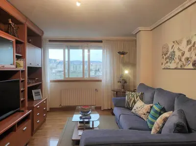 a living room with a couch and a tv at Con vistas al puente del Milenio y plaza de garaje in Ourense