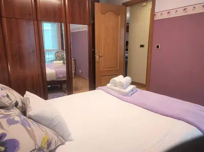a bedroom with a bed with two towels on it at Con vistas al puente del Milenio y plaza de garaje in Ourense