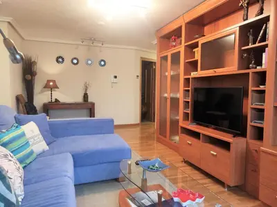 a living room with a blue couch and a tv at Con vistas al puente del Milenio y plaza de garaje in Ourense
