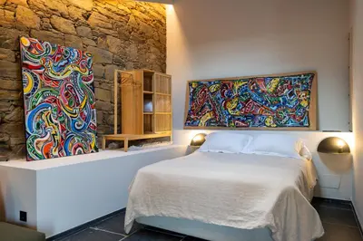 a bedroom with a bed and two paintings on the wall at A Rectoral de Seadur in Seadur