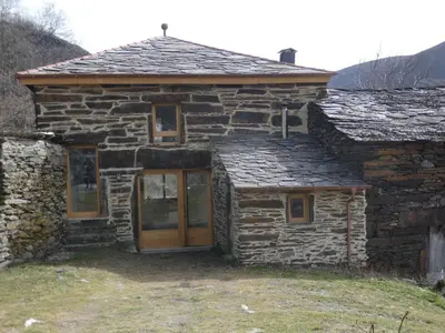 an old stone house with a wooden door at Casa de montaña - A Palleira do Curralón in Pradoalvar