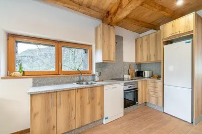 a kitchen with wooden cabinets and a white refrigerator at Casa de montaña - A Palleira do Curralón in Pradoalvar