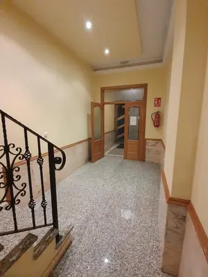 an empty hallway with a staircase and a door at A menos de doscientos metros de la playa in Foz