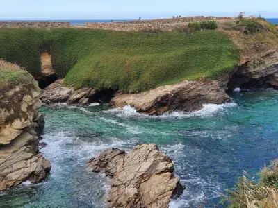 an aerial view of a river between two cliffs at A menos de doscientos metros de la playa in Foz