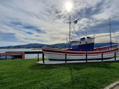 a boat sitting on the grass near the water at A menos de doscientos metros de la playa in Foz