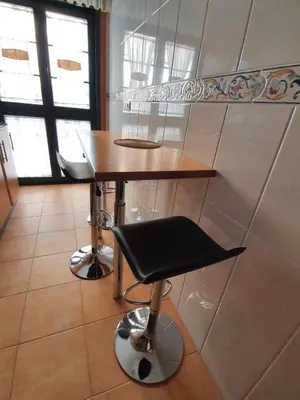 a small table and a stool in a kitchen at A menos de doscientos metros de la playa in Foz