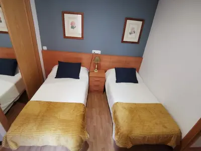 two beds in a small room with blue walls at A menos de doscientos metros de la playa in Foz