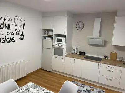 a kitchen with white cabinets and white appliances at Casa Daló II in Folgoso